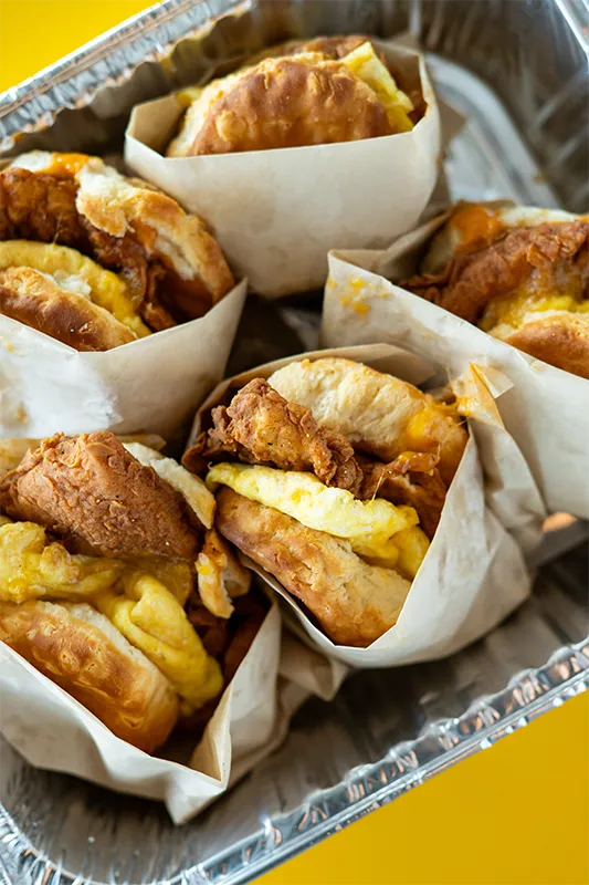 Chicken biscuit breakfast sandwiches in a catering tin