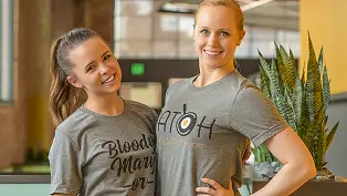 Two Hatch employees hugging and smiling Two Hatch employees hugging and smiling