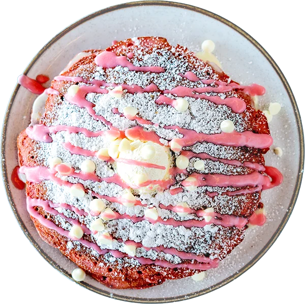 A pink strawberry pancake with powdered sugar and icing.